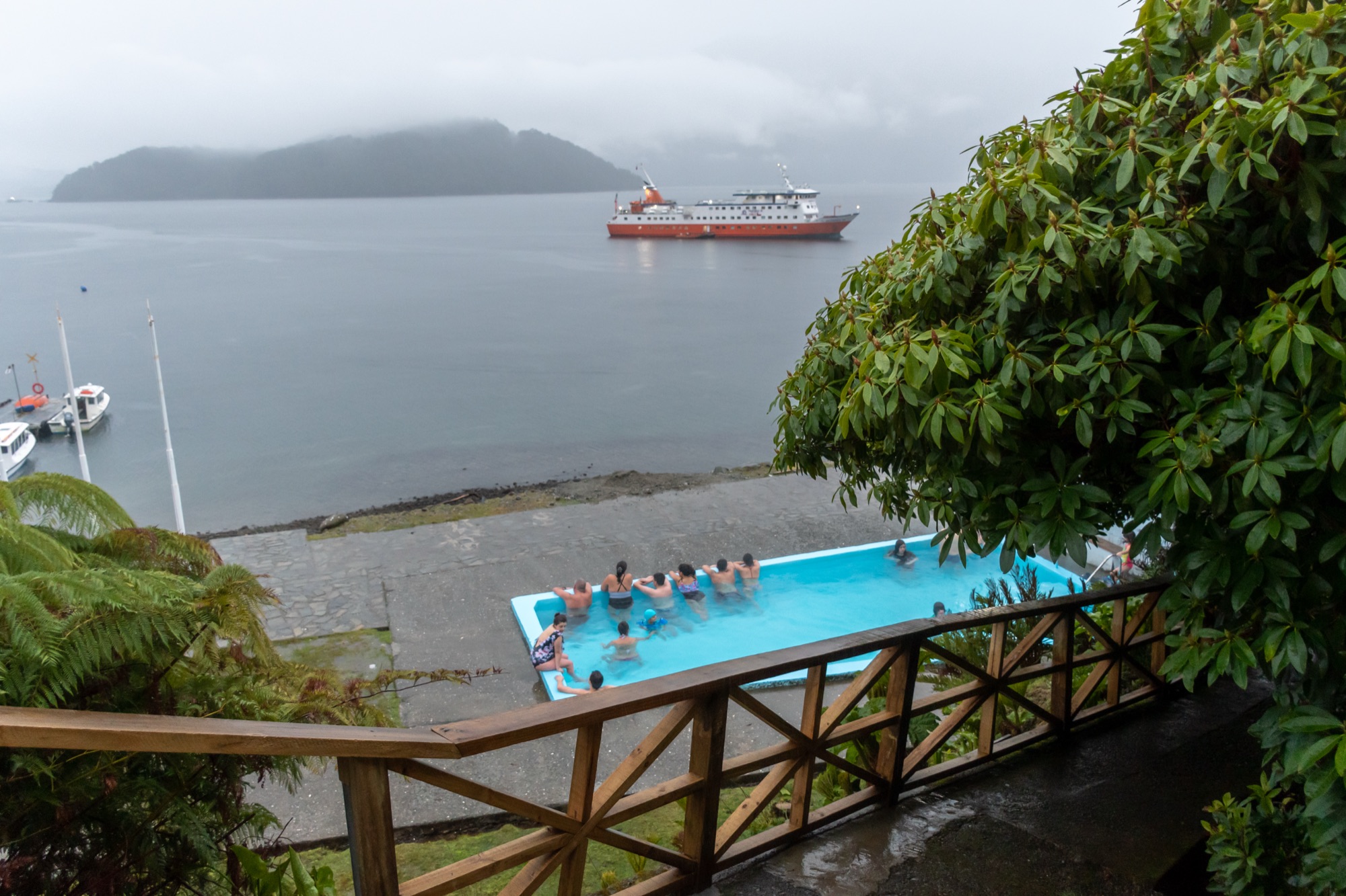 Piscina de las Termas de Llancahué con el Skorpios al fondo