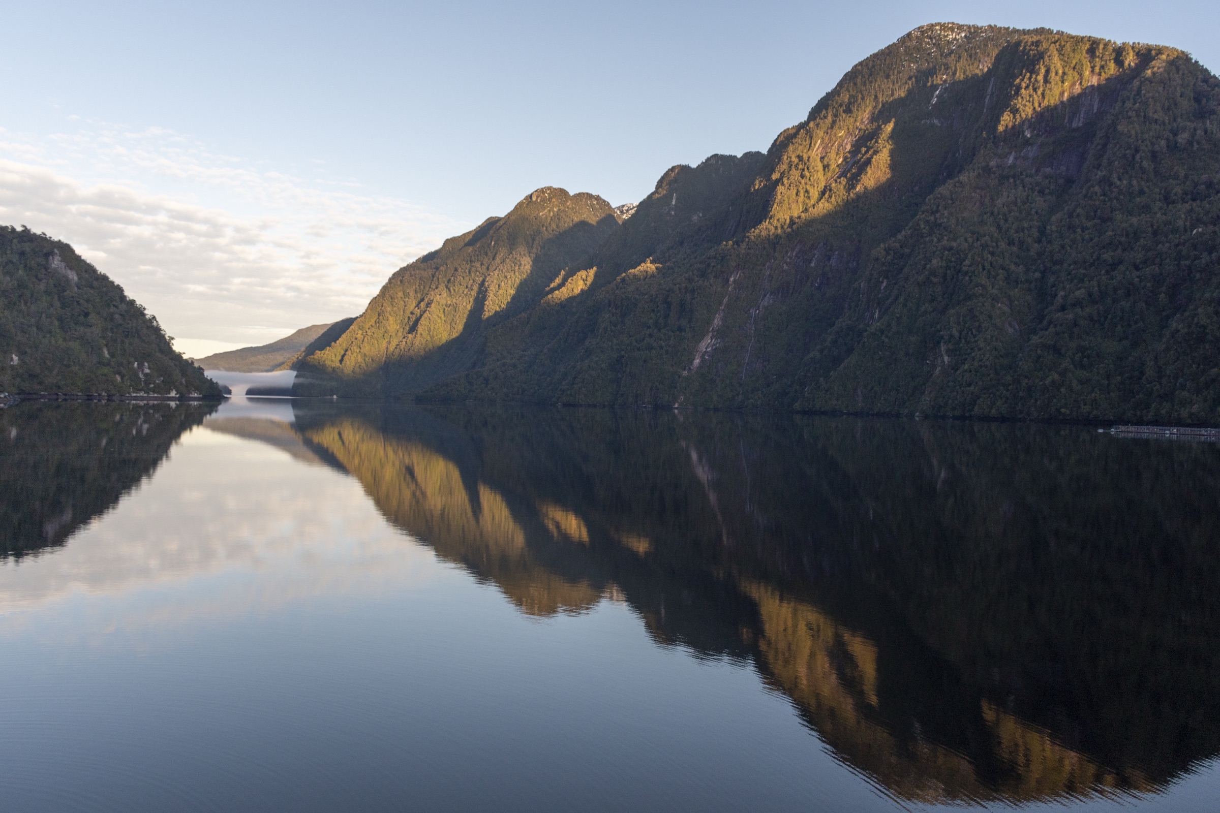 Montañas patagónicas reflejadas en las aguas en calma del fiordo